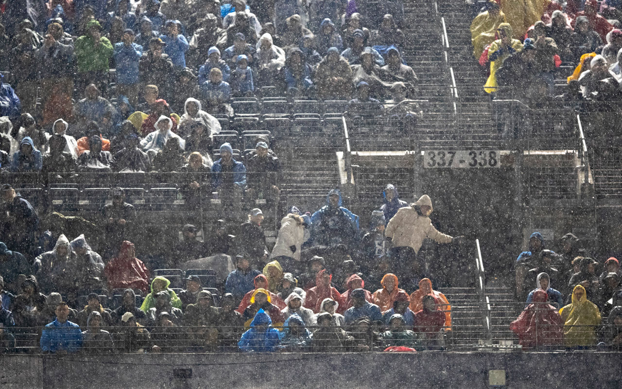 Fans at SoFi Stadium look on during a weather delay shortly before